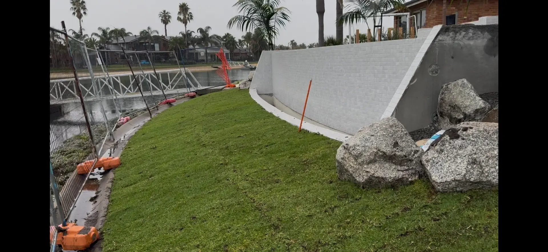 Newly laid lawn along a retaining wall by the water